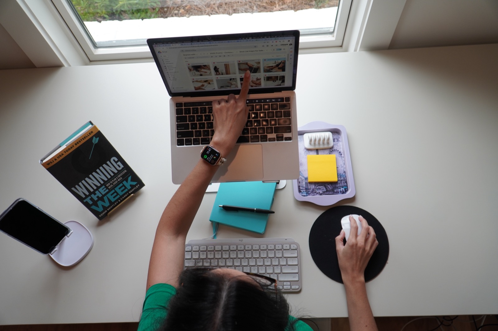 Carey's workspace: laptop, planner, and the Winning the Week book